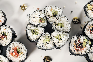Set of rolls with red fish and ginger. Table setting. Black background.