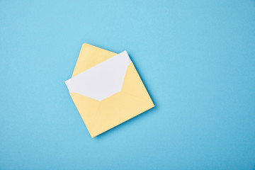 yellow envelope with blank white card on blue background
