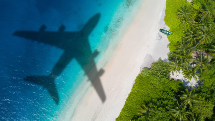 Travel concept with airplane shadow and beach