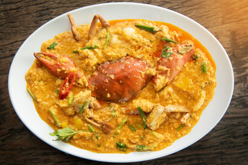 Fried crab with curry powder,one of the popular food in Thailand with a wood table background