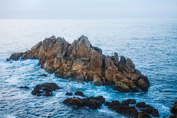 LANDSCAPE OF COAST FROM THE CLIFF WITH ROCKS ISLAND AND BLUE SKY HORIZON ON THE COSTA DE GALICIA IN SPAIN