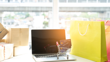 credit card in a trolley on a laptop with shopping bag