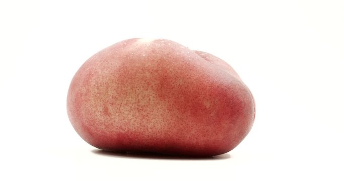 Donut peach isolated rotates on itself on white background. Snuffbox, Saturn, Tabacchiera rotation. Organic fruit.