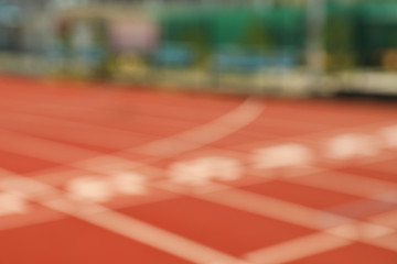 Start of red athletic track with numbers, blurred background