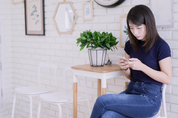 Portrait of pretty asian woman working comfortably and use smartphone at her apartment,Lifestyle Concept