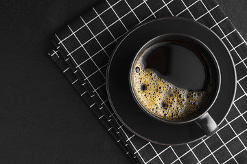 Black coffee Cup on napkin and black concrete table,dark background