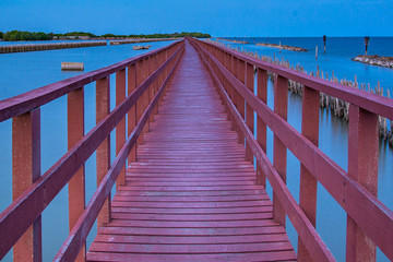 Fototapeta premium Beautiful of The walkway red wooden bridge in evening at Bang Khun Thian sea view, Bang Khun Thian, Bangkok.