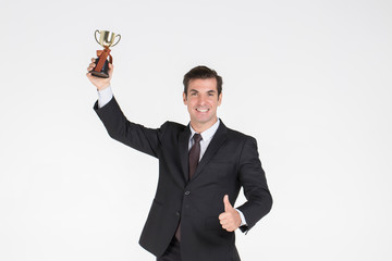 Successful Businessman handsome wearing a suit with tie Glad to win the business competition and thumb up hold gold words .