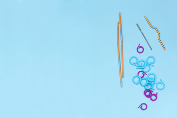 Crochet hooks and accessories on blue background. Tool for handmade knitting. Copy space for text