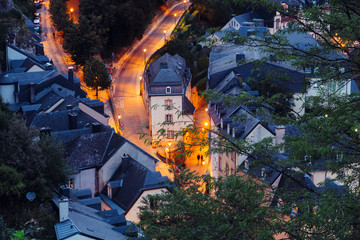 Two people are walking in  Grund Quarter in Luxembourg City during night.  The Old Town of Luxembourg is a UNESCO World Heritage Site. This part of the city is known as the Grund Quarter.