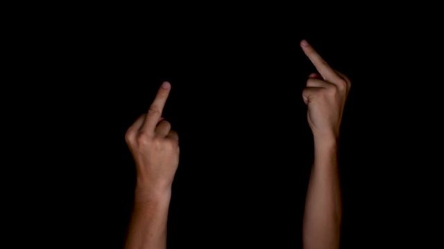 Close-up view of a male gesturing with his middle fingers, indicating his disrespect and anger, commonly known as "fuck you" sign