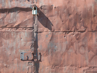 rusty lock hanging on old iron gate