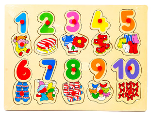 Wooden puzzle with numbers and arithmetic signs with pictures of items. Children's hand takes the figures from the puzzle. Preschool educational game for the development of memory, logical thinking