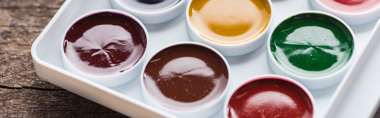 close up view of watercolor new fresh paint palette, panoramic shot