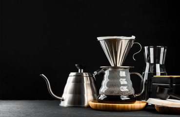 Alternative coffee brewing method,pure over,glass teapot on wooden tray with freshly brewed coffee on dark background.
