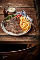 Barbecued or grilled T-bone steak and French fries