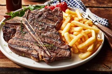 Foto op Canvas Tasty grilled T-bone steak seasoned with herbs © exclusive-design
