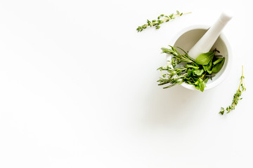Homeopathy with leaves and healing herbs for making oil on white background top view copyspace