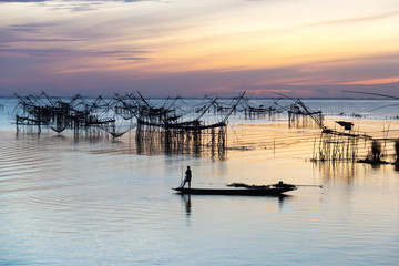 Fototapeta premium Silhouette of square dip nets with sunrise sky background, livelihoods of fishermen at Pakpra, Phatthalung in Thailand
