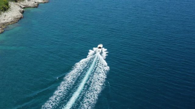Aerial Panoramic Tracking  speedboat cruising high speed in Adriatic Sea. Following From up to Sea level of Luxury small boat sailing on crystal clear water Mediterranean paradise In Rabac, Croatia.