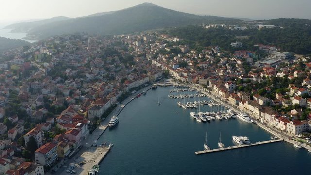 Aerial panoramic view over Mali Losinj Town, Croatia. European city sea front, Harbor with yacht, boat and ship. Croatian Island with blue water. Mediterranean Bay.