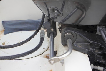 Motor boat hydraulic steering with transom outboard engine close-up - clamp, cylinder, pipes and...