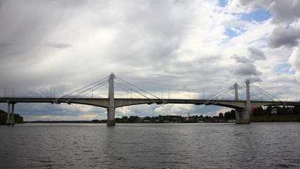 Large bridge across the Volga river in the city of Kimry the Tver region on a summer day on the background of a stormy sky with clouds, panoramic view from the water