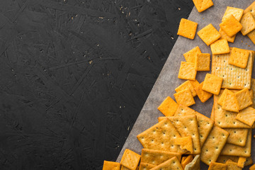 Salty square crackers on a paper and dark concrete background