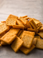 Salty square crackers on a paper and dark concrete background