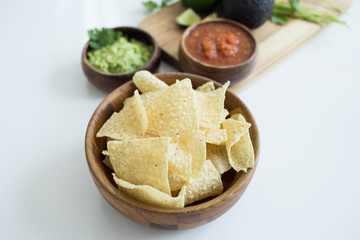 Chips with salsa and guacamole on white background