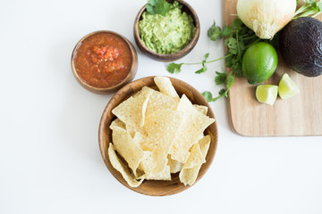Chips with salsa and guacamole on white background