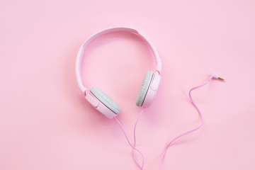 Pink headphones on pink background. Music concept