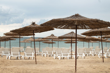 Sun loungers, protective umbrellas on the beach on the sea coast