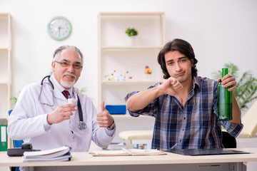 Obraz premium Young male alcoholic visiting old doctor