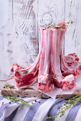 Raw lamb ribs, spices and herbs against white wooden wall