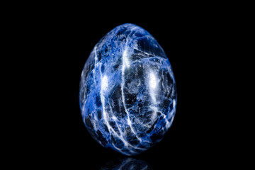 Sodalith form oval getrommelt vor Hintergrund schwarz, Mineralien und Heilsteine