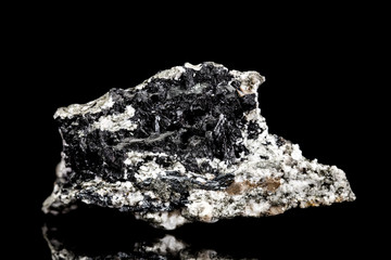 Turmalin oder Schörl Rohstein auf Muttergestein vor Hintergrund schwarz, Mineralien und Heilsteine