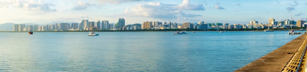 Obraz premium Sanya town evening cityscape, view from Phoenix island on Hainan Island of China