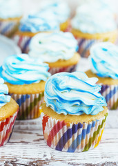 cupcakes with cream cap blue on white wooden background