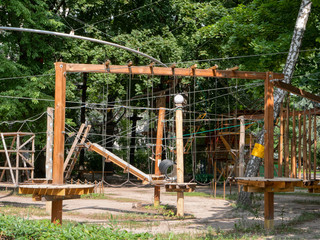 Fototapeta na wymiar empty rope amusement climbing park in woods. nobody in frame