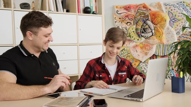 Dad and son have fun doing the hometask together slow motion