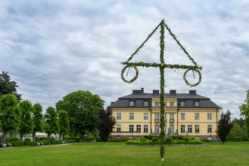 Swedish holiday midsummer by raising the maypole covered in flowers and leaves.