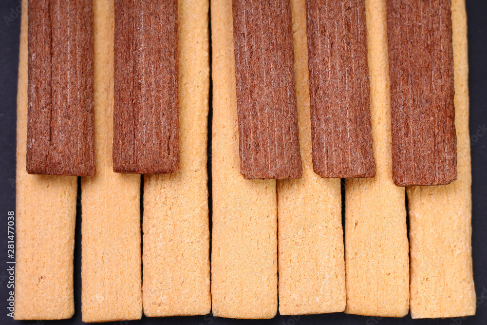 Wall mural Light and dark, black and white fitness cookies with fiber laid out in the form of piano keys. Nutrition harmony concept