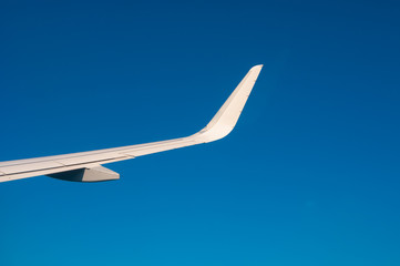 Airplane wing on blue sky