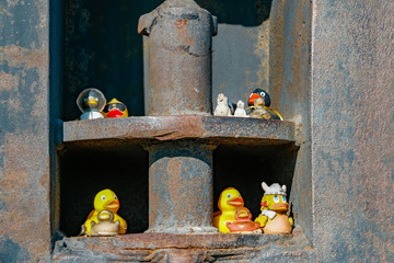 Entenfiguren sitzen in einem Eisenpuffer im Hafen