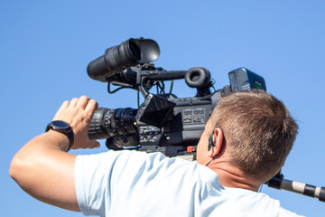 The operator takes the camera. Work on shooting video. Shooting on the street in the summer. Job professional