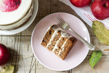Apple cake with curd cream, decorated with painted apple on the background of autumn composition. Rustic style.