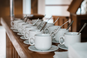 Cups with spoons for tea on a wooden table in a cafe