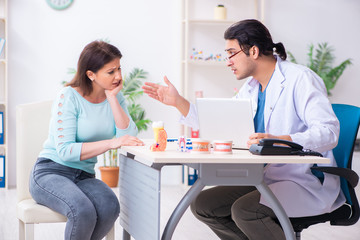 Fototapeta premium Middle-aged woman visiting male doctor stomatologist