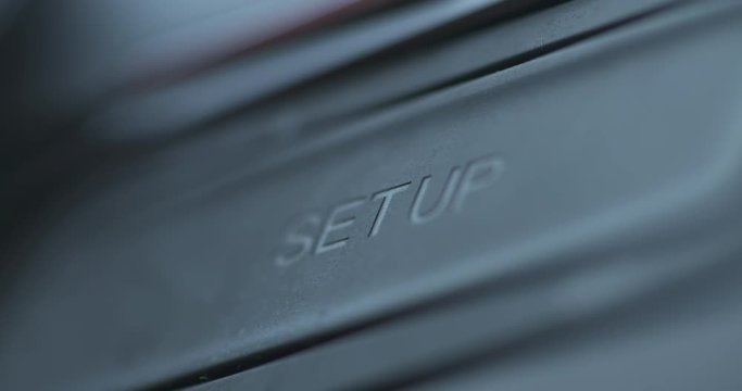 Finger pushing the setup button on a vehicle dash
